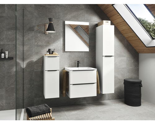 Badezimmer mit Waschbeckenunterschrank, Spiegelschrank, Hochschrank, Lampe und Wäschekorb in einem hellen Raum