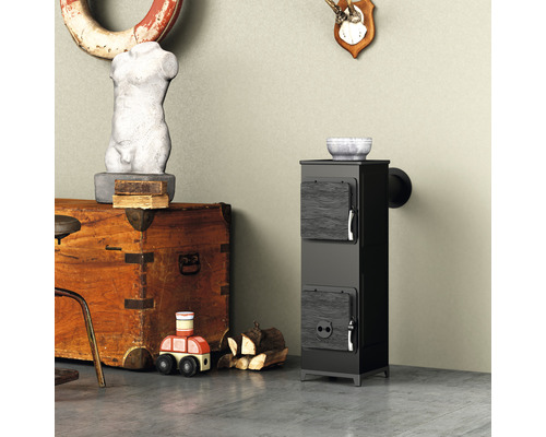 Schwarzer Kaminofen neben Holztruhe und Holzspielzeug