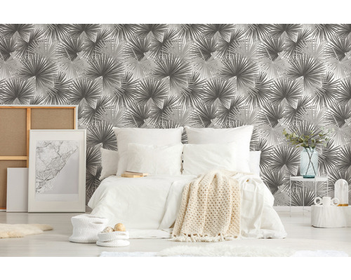 Chambre avec papier peint à motifs, lit et articles de décoration pour une ambiance chaleureuse.