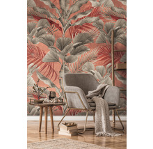Salon avec fauteuil, table et décoration devant un mur avec papier peint à feuilles