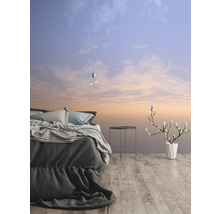 Schlafzimmer mit Bett, Beistelltisch, Blumenvase und Tapete mit Himmelsmotiv