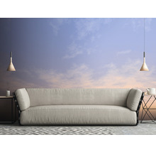 Wohnzimmer mit Sofa, Beistelltischen, Pendelleuchten und gemustertem Teppich