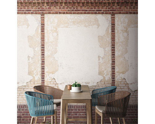 Terrassenszene mit Tisch und Stühlen vor einer Backsteinmauer