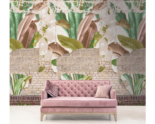 Canapé rose devant un mur avec du papier peint à motifs de feuilles et de la maçonnerie apparente