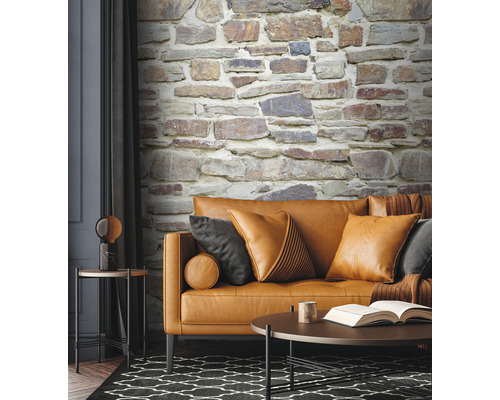 Wohnzimmer mit Couch, Kissen, Tisch und Steinwandtapete