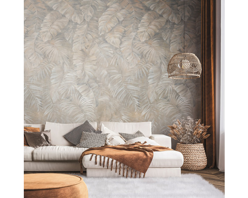 Wohnzimmer mit gemusterter Tapete, Sofa, Kissen und Lampe.