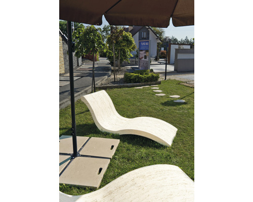 Mobilier de jardin : Chaise longue incurvée en pierre sous un parasol sur une pelouse