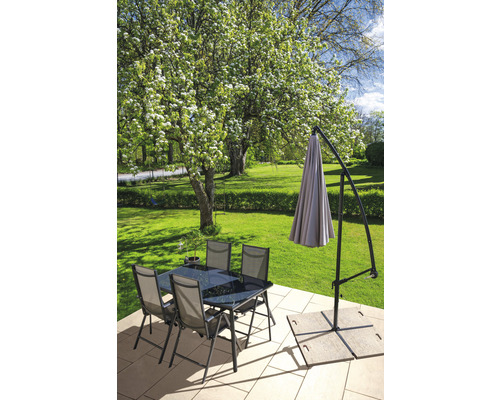 Scène de jardin avec table à manger, chaises et parasol sur une terrasse