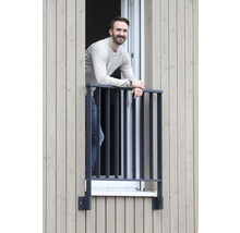 Person steht an einem Fenster mit einem Metallgeländer
