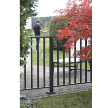 Garten mit Metallzaun, Tisch und Person mit Wasserschlauch