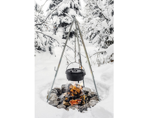Kessel über Lagerfeuer an einem Dreibein im Schnee