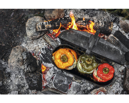 Gefüllte Paprika in einem Topf über einem Lagerfeuer.