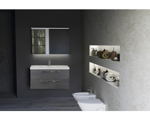 Salle de bains avec meuble sous-lavabo, miroir avec éclairage, bidet et toilettes.