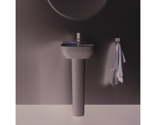 Scène de salle de bains avec lavabo, robinet, serviette et miroir