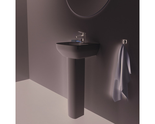 Lavabo avec colonne, robinet et serviette dans la salle de bain