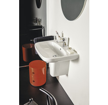 Weißes Wandwaschbecken mit Armatur und Badaccessoires in einem Badezimmer.