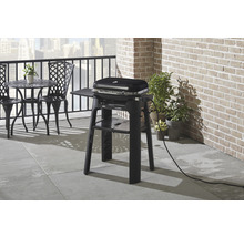 Elektrischer Grill auf einem Balkon mit Tisch und Stühlen.