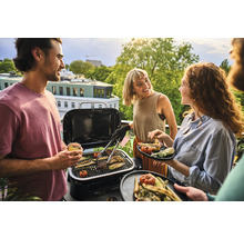 Personen grillen mit einem tragbaren Grill auf einem Balkon