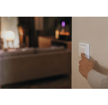 Eine Hand betätigt einen Lichtschalter im Wohnzimmer.