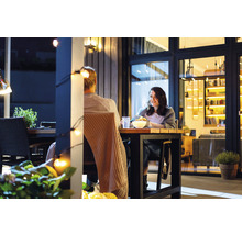 Scène du soir avec un couple à une table de jardin sur une terrasse