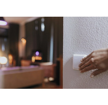 Une main actionne un interrupteur dans un espace de vie.
