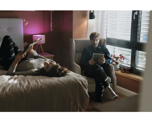 Helles Schlafzimmer mit Personen, Bett, Sessel und Tageslicht