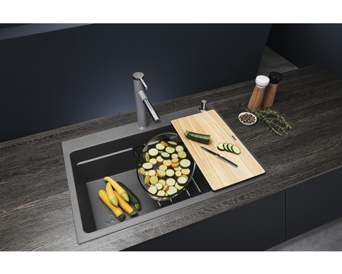 Évier de cuisine avec robinet, planche à découper et courgettes coupées