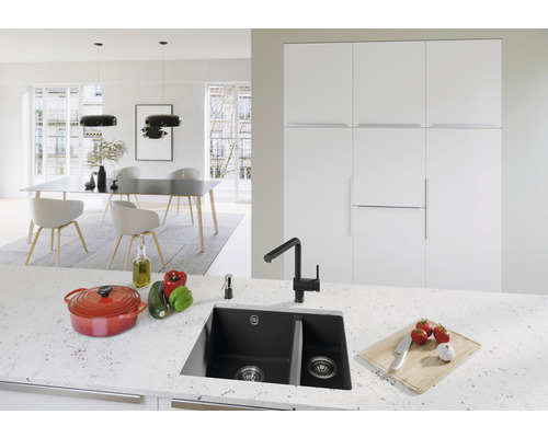 Cuisine moderne avec évier noir, marmite et table à manger