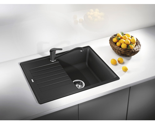 Spüle mit Abtropffläche und Armatur auf einer Küchenarbeitsplatte.