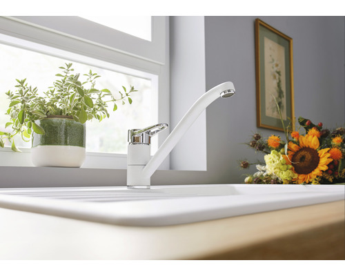 Küchenspüle mit weißer Armatur vor einem Fenster