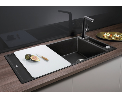 Küchenspüle mit Schneidebrett, Armatur und Spülmittelspender in einer hellen und organisierten Küche