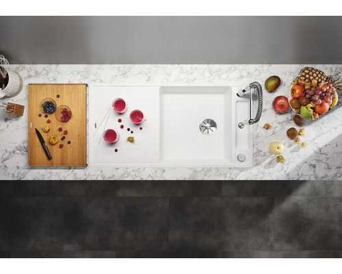 Küchenszene mit Spüle, Armatur, Schneidebrett, Gläsern und Früchten von oben