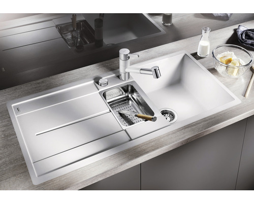 Évier avec égouttoir, lavabo, robinet de cuisine et accessoires sur un plan de travail de cuisine.