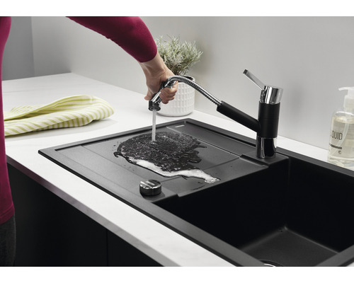 Évier de cuisine noir avec robinet et douchette dans une cuisine lumineuse
