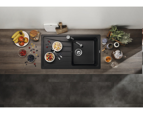Vue de dessus d''un évier de cuisine noir moderne avec des ingrédients pour le petit-déjeuner sur un plan de travail en bois