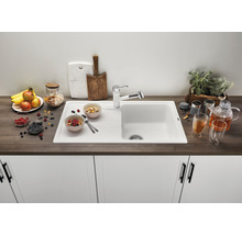 Évier de cuisine avec égouttoir, robinetterie et aliments décoratifs sur un plan de travail