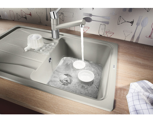 Spüle mit Wasserhahn und Geschirr auf einer Arbeitsplatte