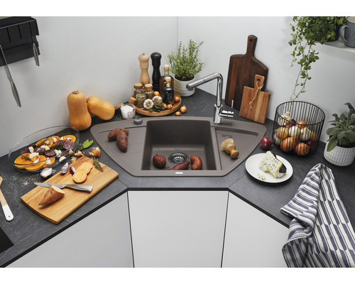 Évier d''angle en matériau composite dans une cuisine avec des aliments et des ustensiles de cuisine