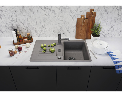 Küchenspüle mit Armatur, Gemüse und Küchenutensilien auf einer Küchentheke