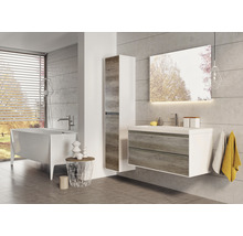 Salle de bains lumineuse avec baignoire, meuble-lavabo avec meuble bas, armoire de toilette et armoire haute.
