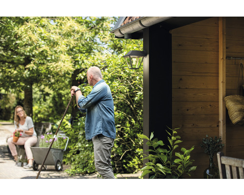 Szene mit Aussenwandleuchte, Personen und Gartenelementen