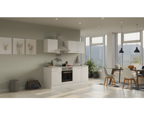 Helle Küche mit Einbauschränken, Dunstabzugshaube und Esstisch im modernen Wohnraum.