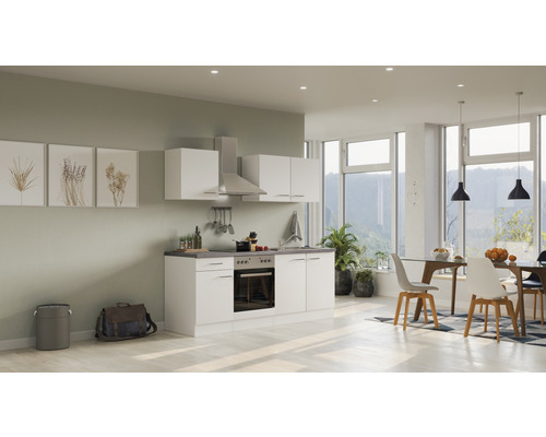 Helle, freundliche Küche mit weißen Schränken, Dunstabzugshaube und Essbereich