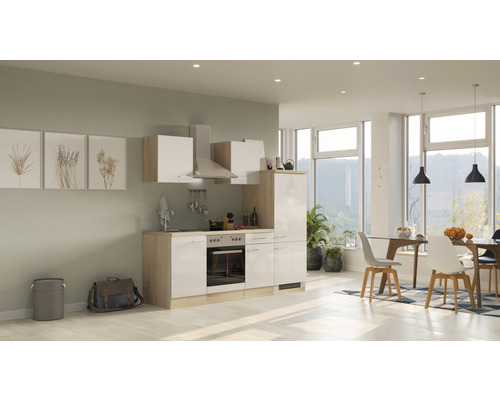 Küchenzeile mit Hängeschränken, Dunstabzugshaube und Esstisch im hellen Raum.