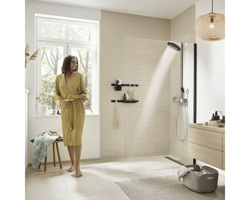 Helles Badezimmer mit Dusche, Ablageregal und Frau im Morgenmantel