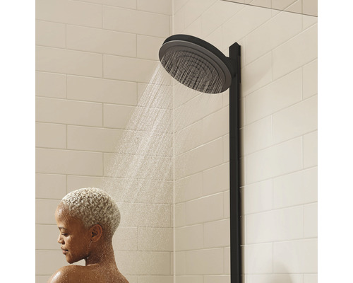 Pomme de douche avec femme sous la douche dans la salle de bain.