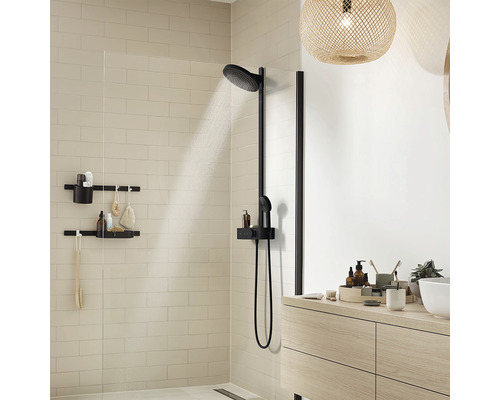 Salle de bains moderne avec colonne de douche noire, douche à effet pluie et étagères de rangement pour les articles de toilette.