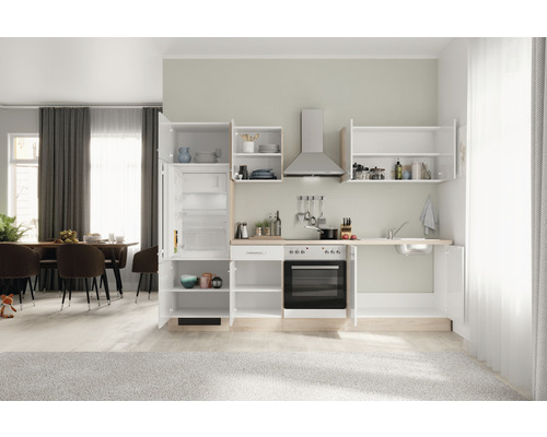 Cuisine claire avec réfrigérateur, évier, cuisinière et hotte aspirante dans un espace ouvert