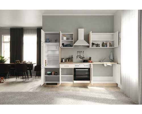 Cuisine équipée avec éléments suspendus, évier, cuisinière et réfrigérateur dans une pièce lumineuse