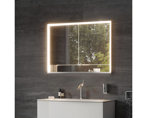 Armoire de toilette éclairée au-dessus d''un lavabo dans une salle de bains.